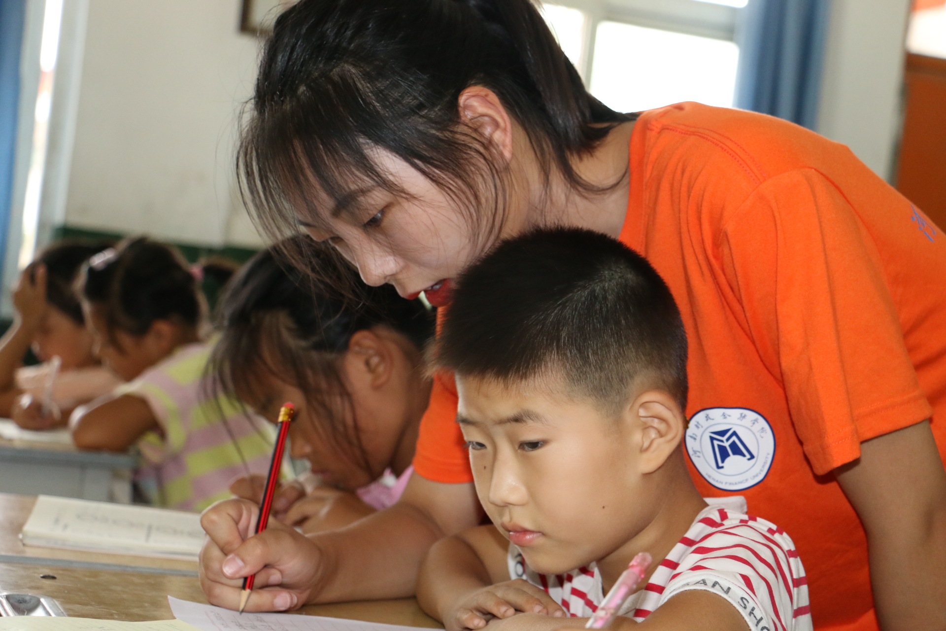 1562986040873615.jpg 志愿者为学生课业辅导.JPG