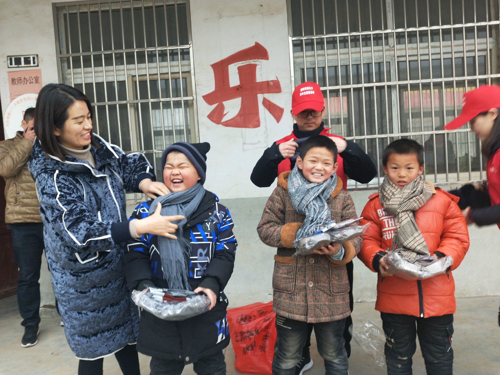 1577265276561220.jpg 图为志愿者为孩子们戴围巾 中国青年报通讯员卢昊供图_meitu_1.jpg